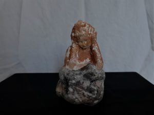 Petite sculpture d'argile, sables colorés sur socle de perre marine.